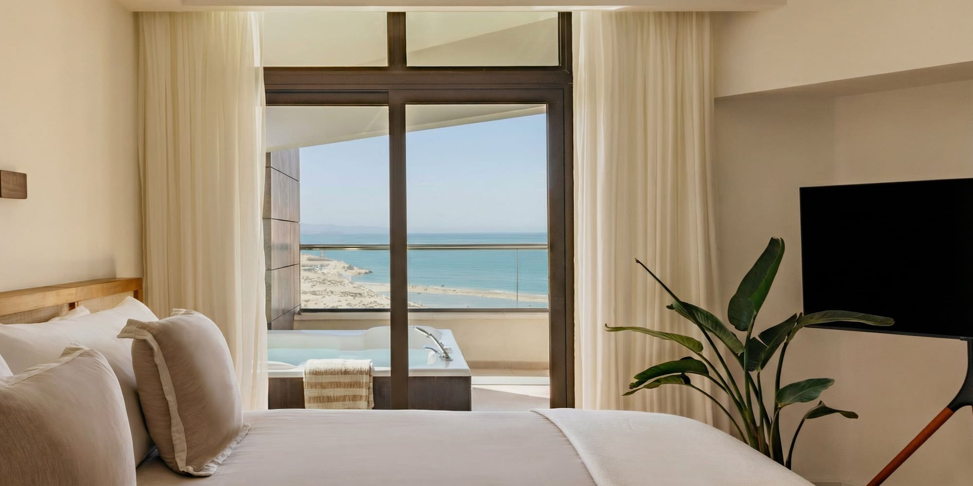 a bedroom with a television and a large window