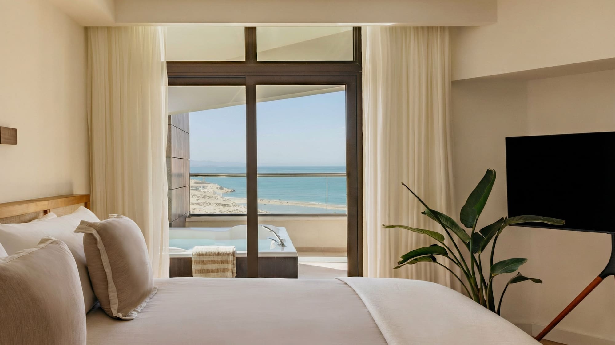 a bedroom with a television and a large window