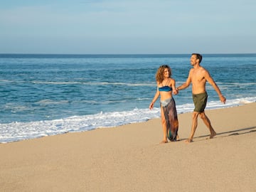 a man and woman walking on a beach