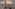 Golden Melia Vinpearl skyscraper, city panorama at sunset, distant mountains.