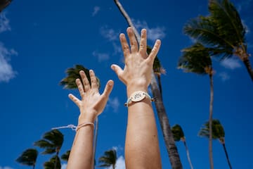 a person's hands reaching out to the sky