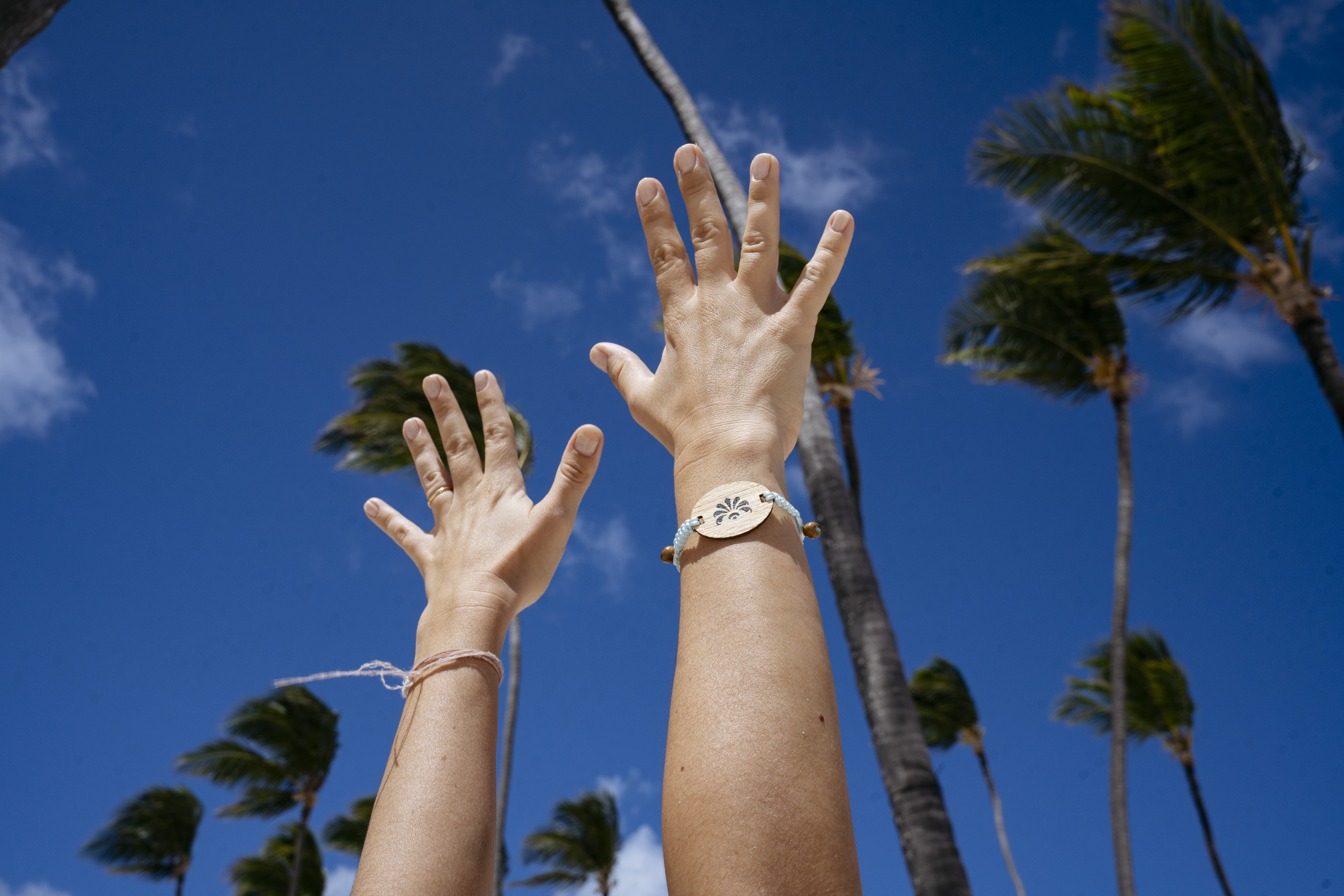 a person's hands reaching out to the sky