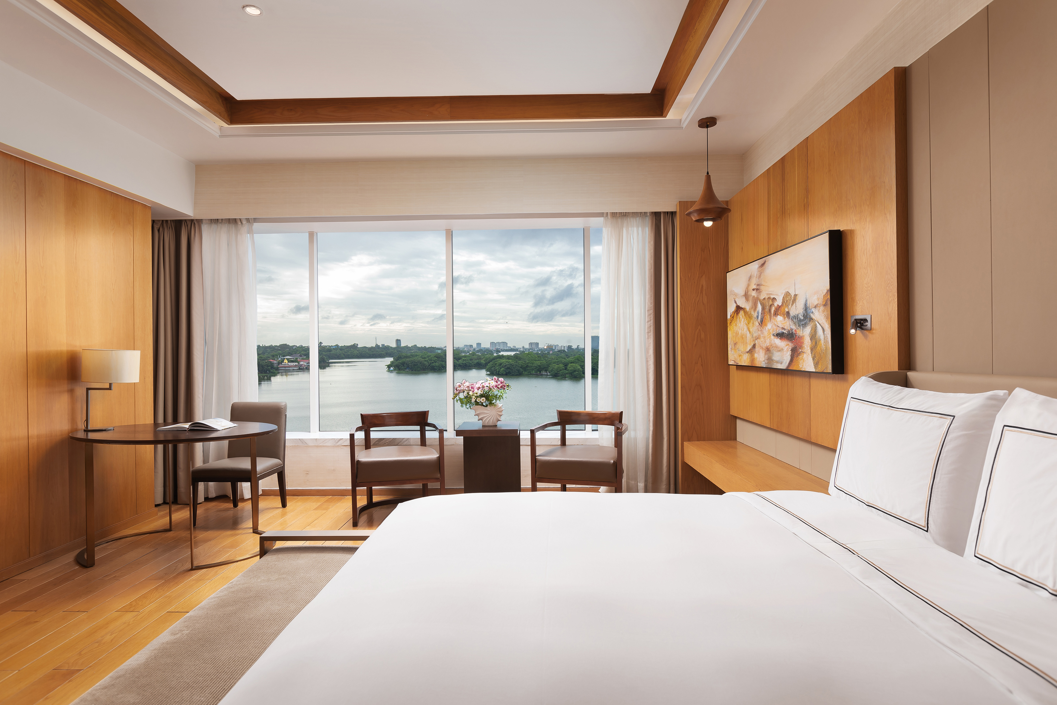 Luxury hotel bedroom with lake view, modern design, and wood accents.