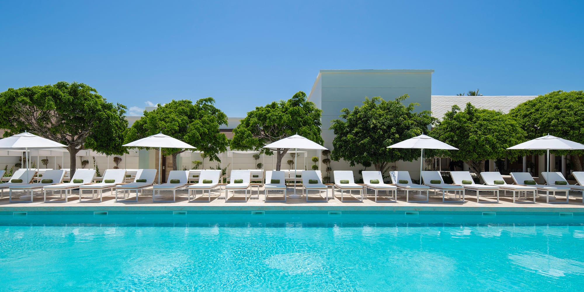 a pool with chairs and umbrellas