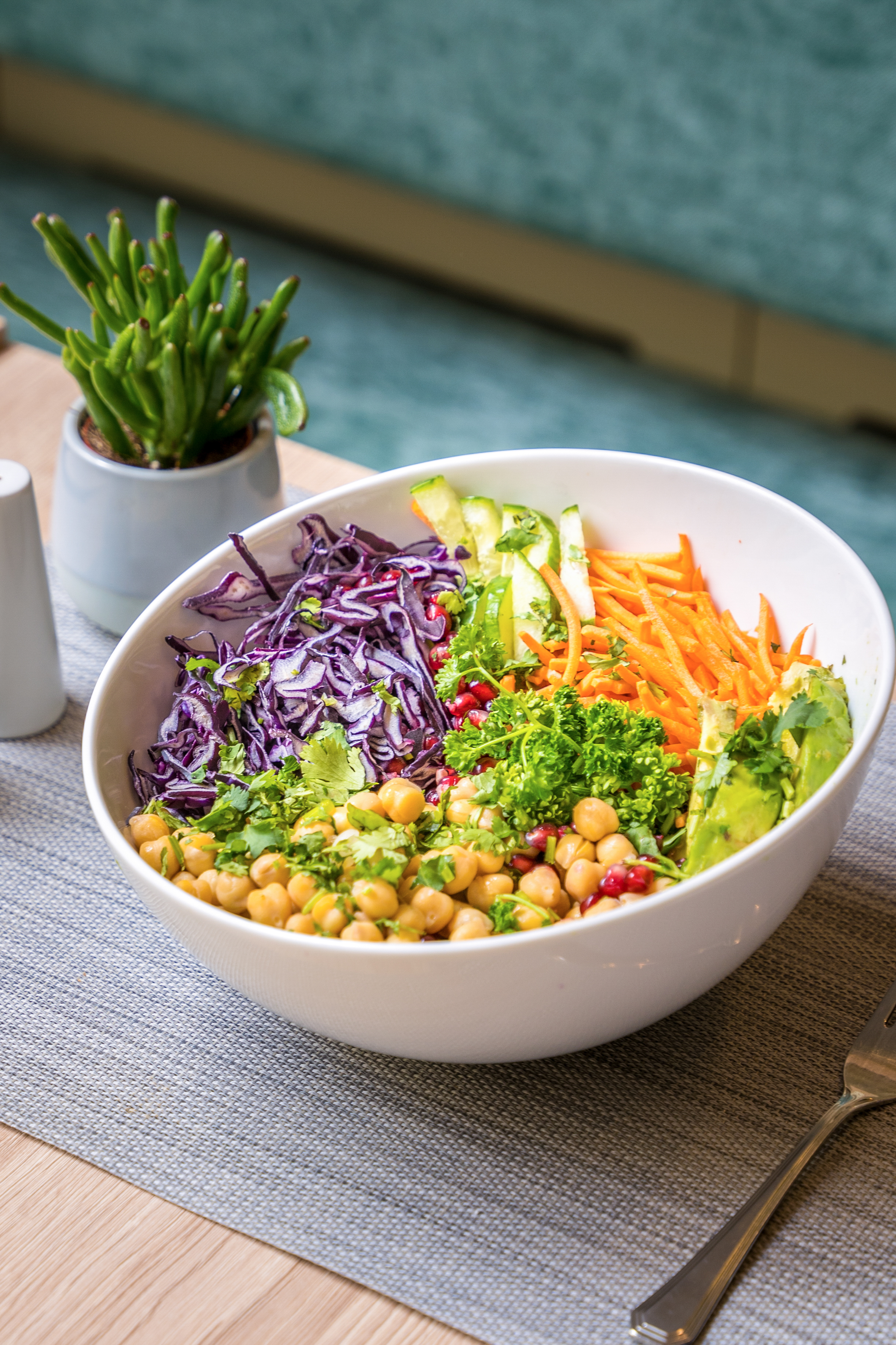 Colorful healthy buddha bowl with chickpeas, purple cabbage, carrots, avocado.