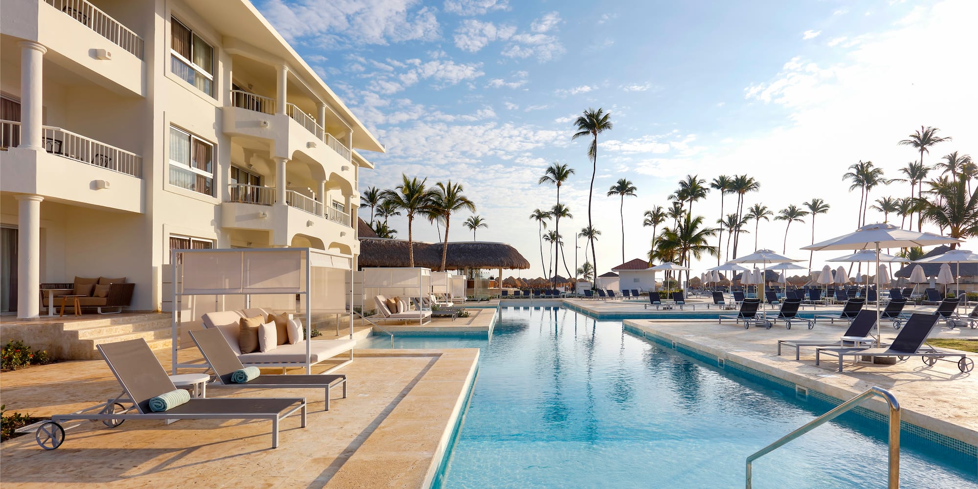 a swimming pool with lounge chairs and palm trees
