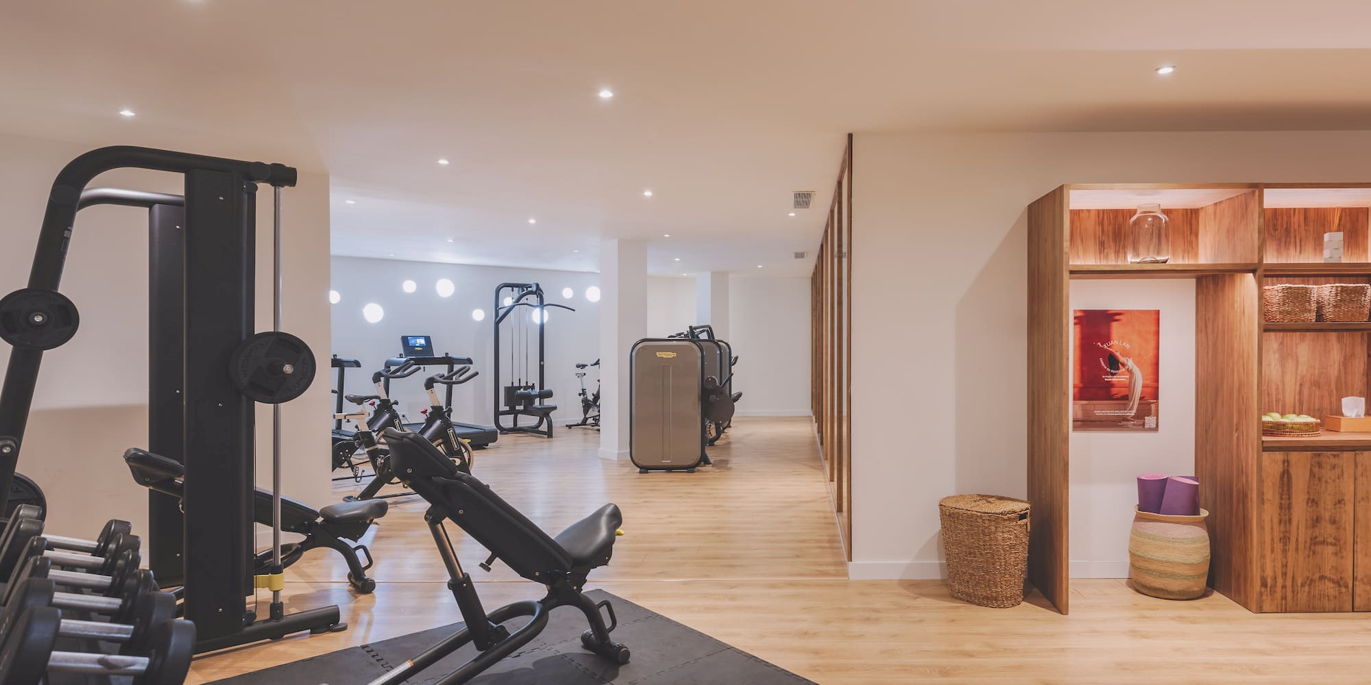 Modern gym with strength machines, free weights, cardio equipment, and yoga.