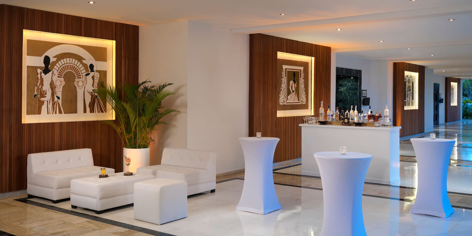 a room with white furniture and a bar