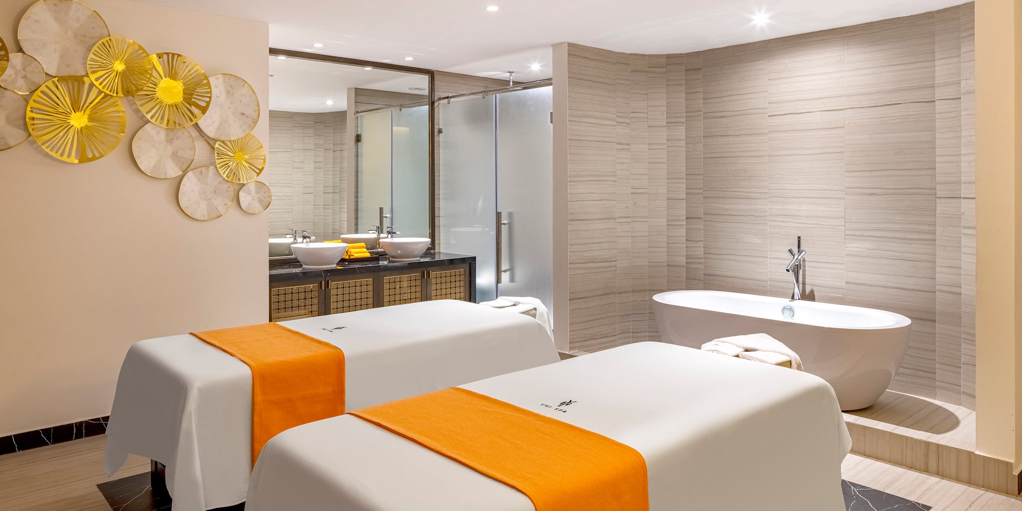 a room with white beds and yellow towels