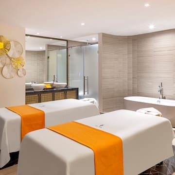 a room with white beds and yellow towels