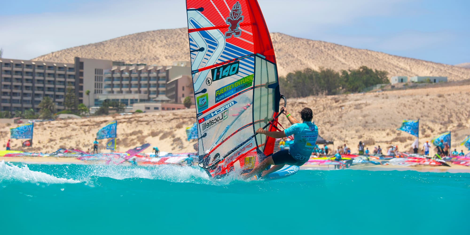 Windsurfer on turquoise water, Fuerteventura Sotavento beach, resort.