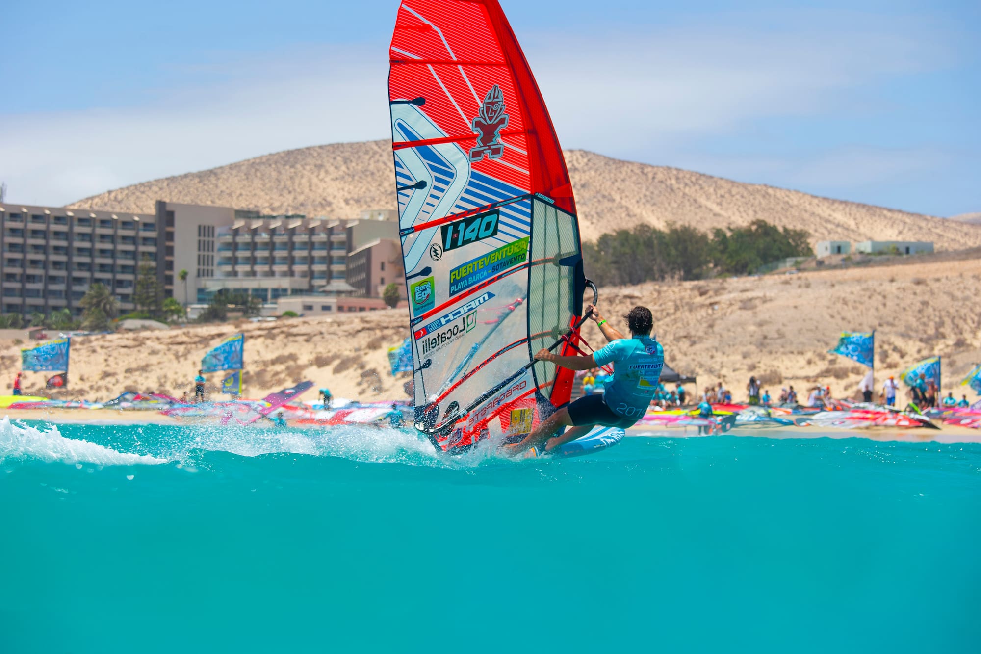 Windsurfer on turquoise water, Fuerteventura Sotavento beach, resort.