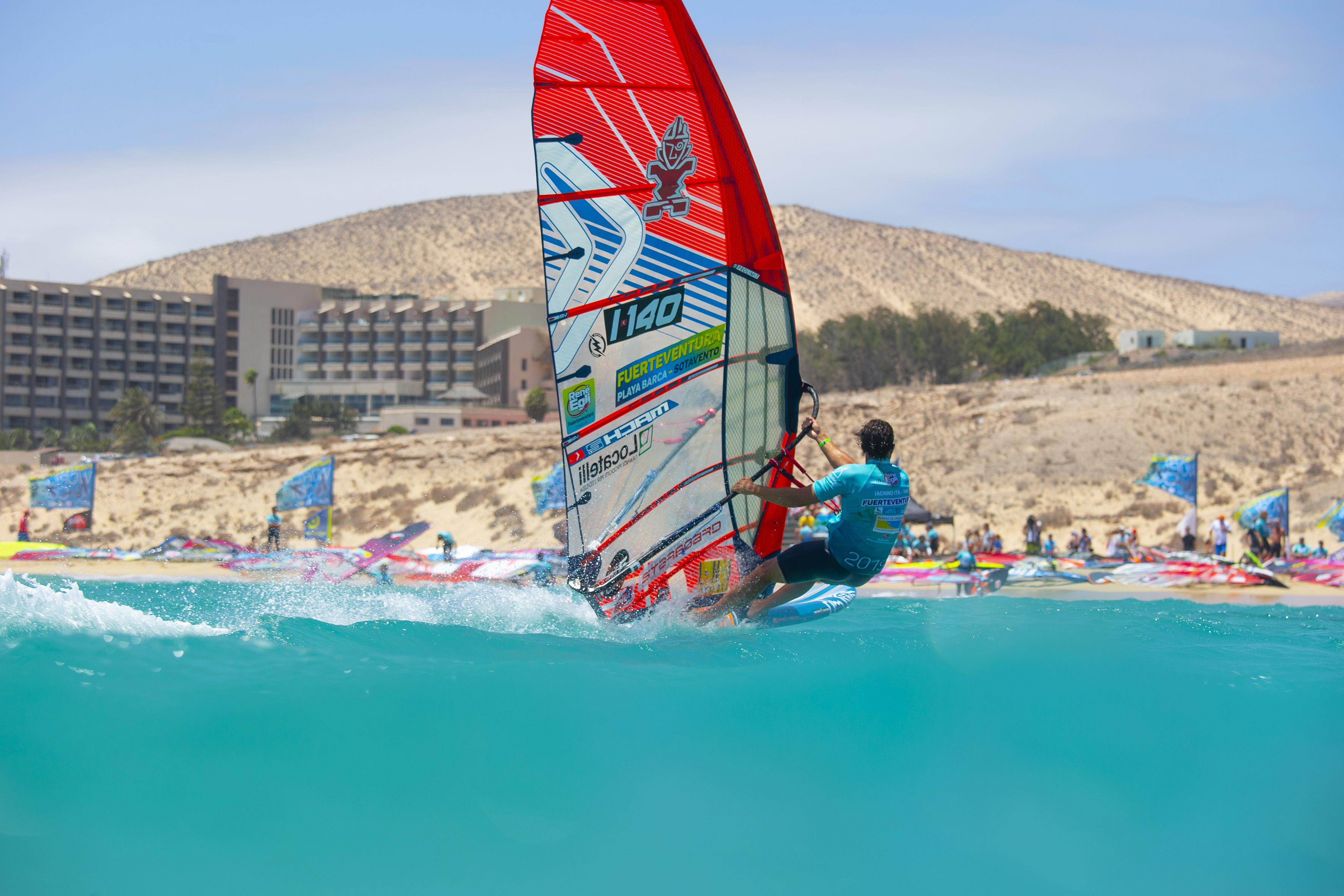 Windsurfer on turquoise water, Fuerteventura Sotavento beach, resort.