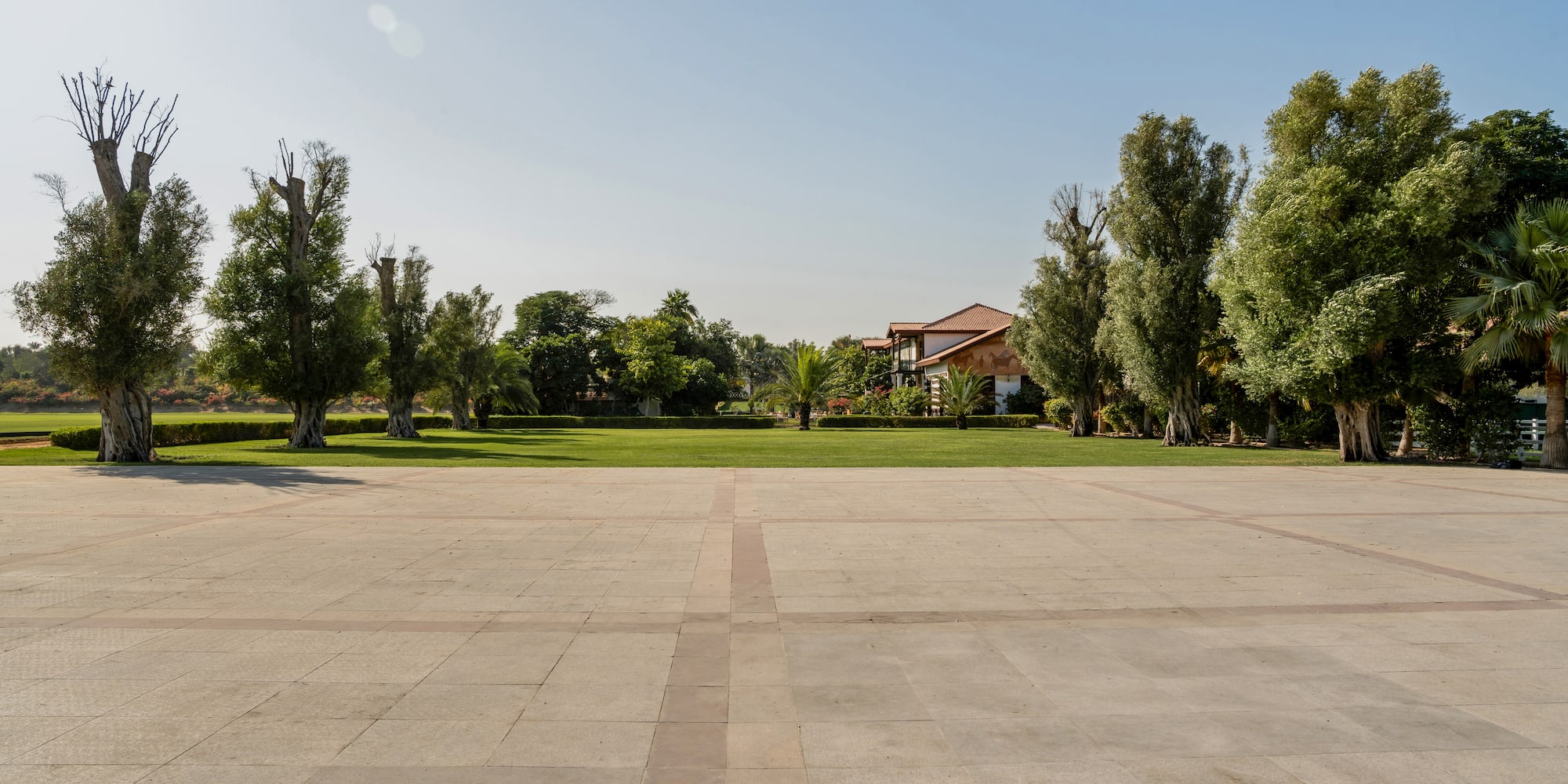 a large square with trees and a house in the background