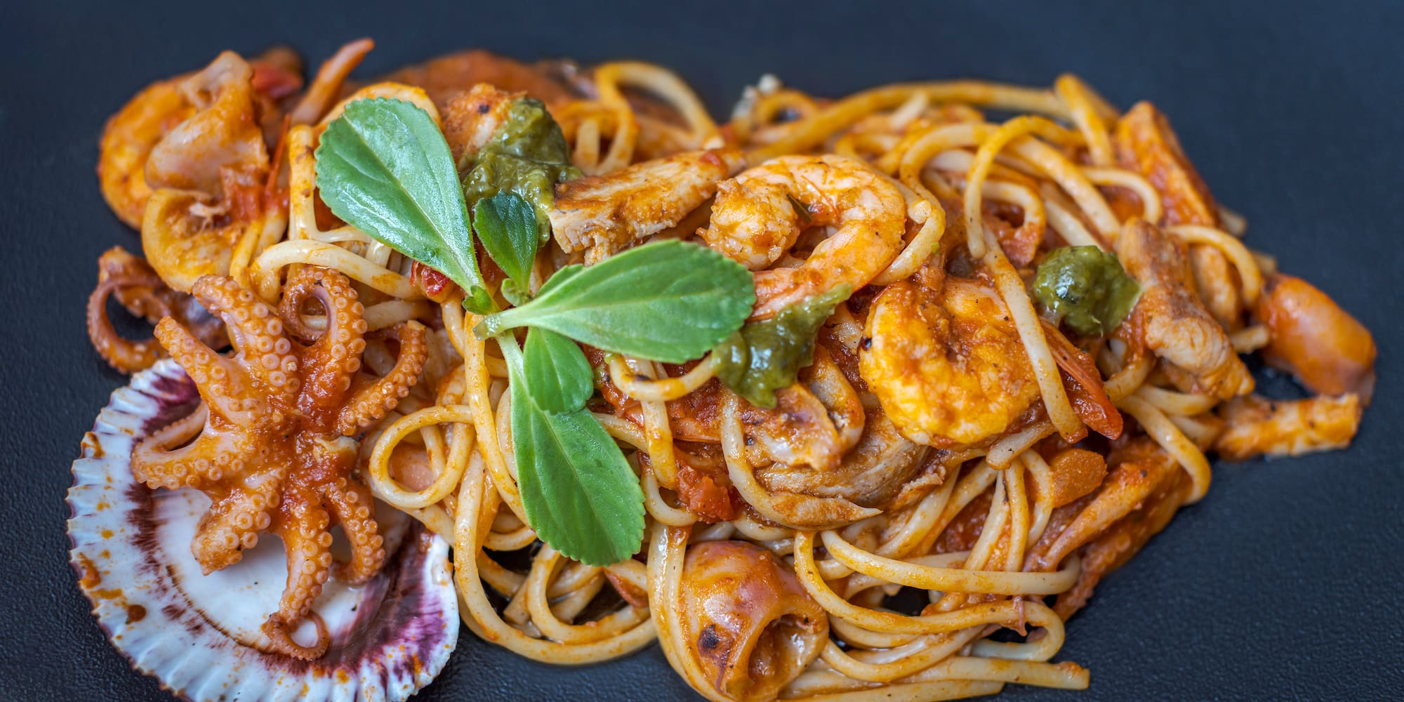 a plate of pasta with seafood and vegetables