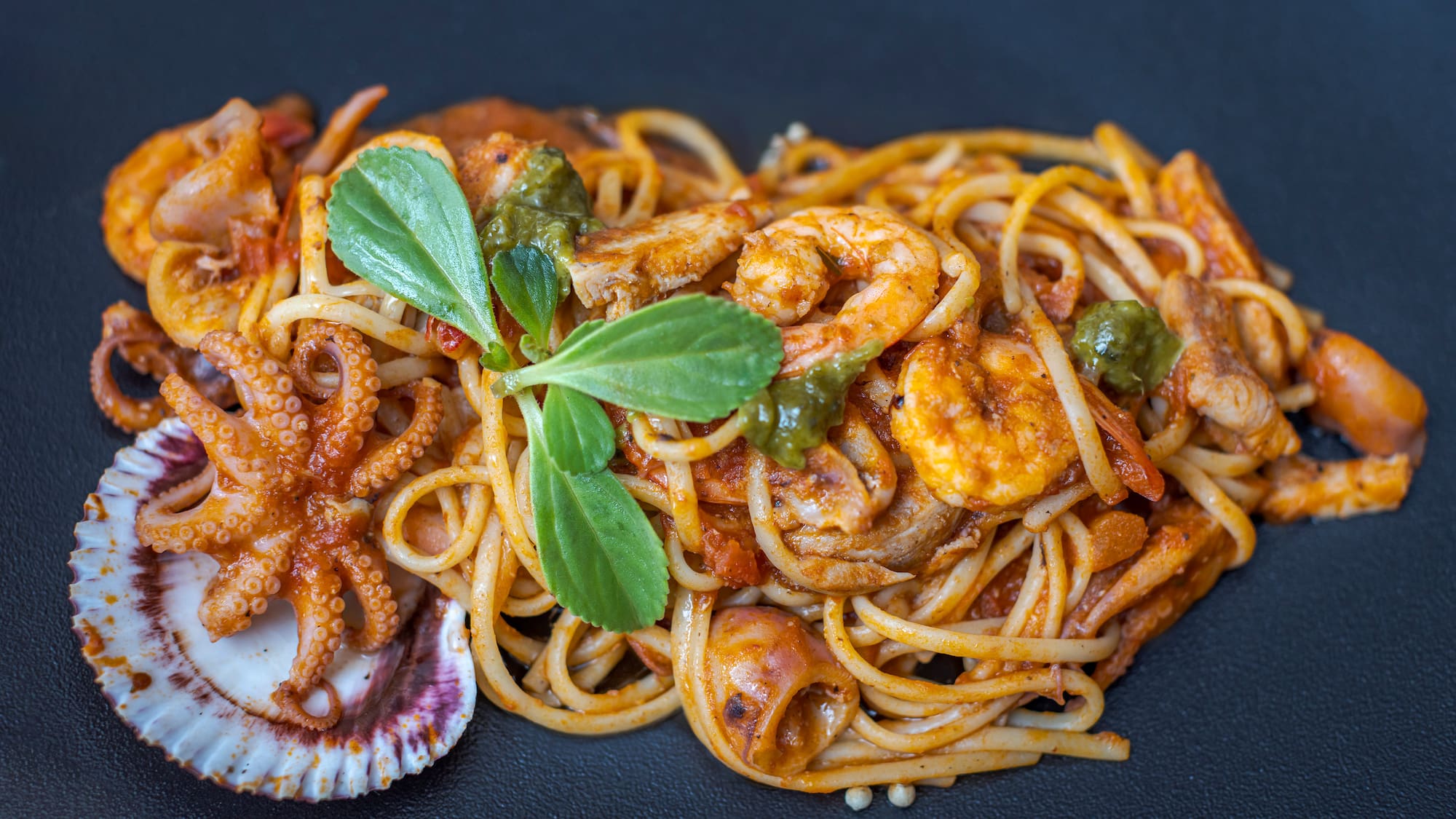a plate of pasta with seafood and vegetables