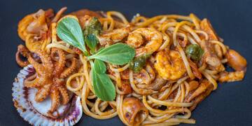 a plate of pasta with seafood and vegetables