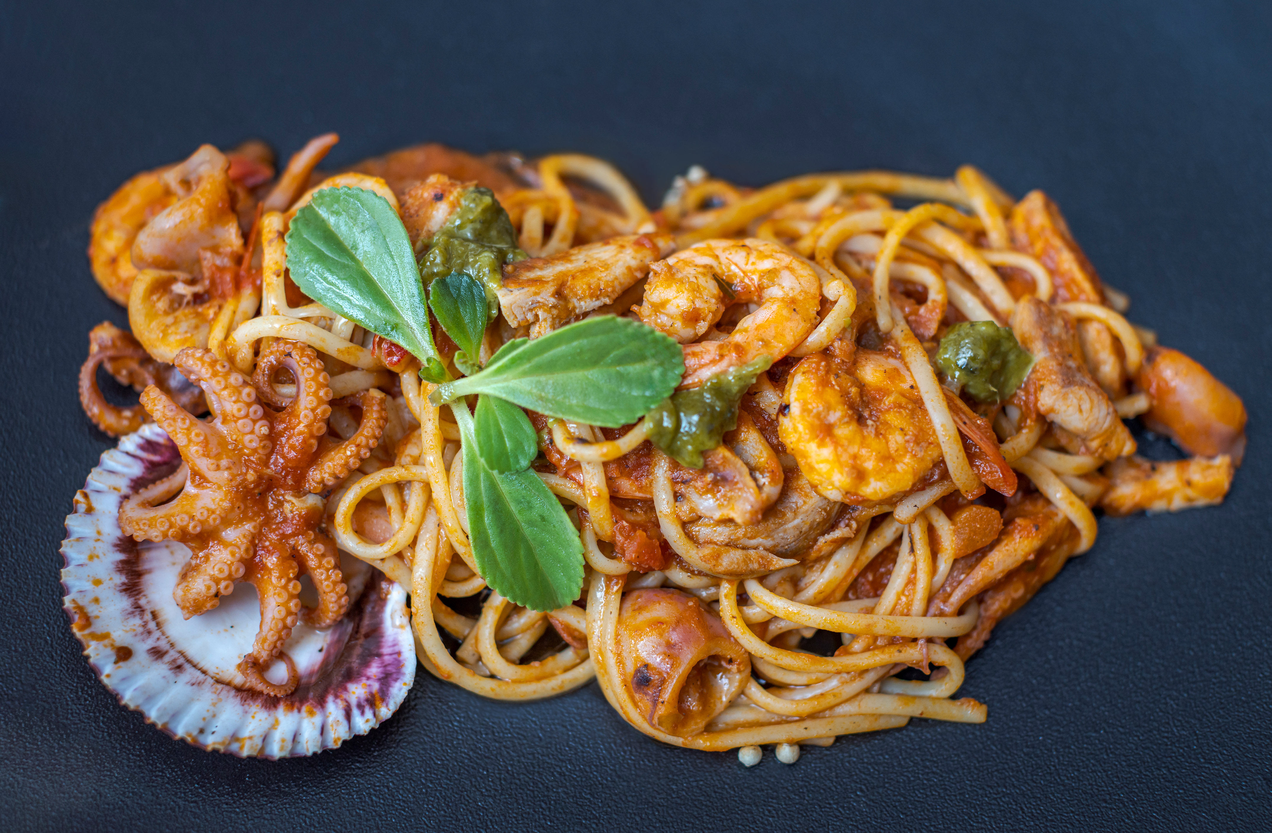 a plate of pasta with seafood and vegetables