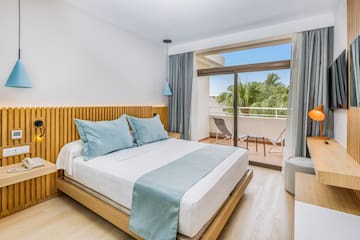 a bed with a glass door and a balcony