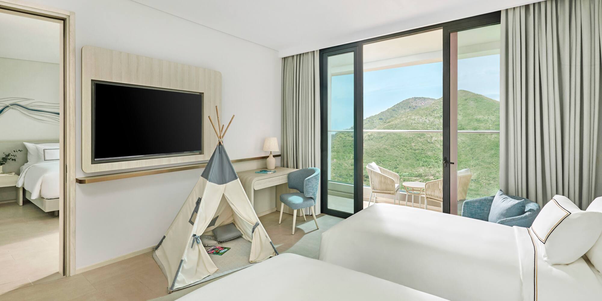 Family room with twin beds, kids' teepee, balcony, and scenic mountain view.