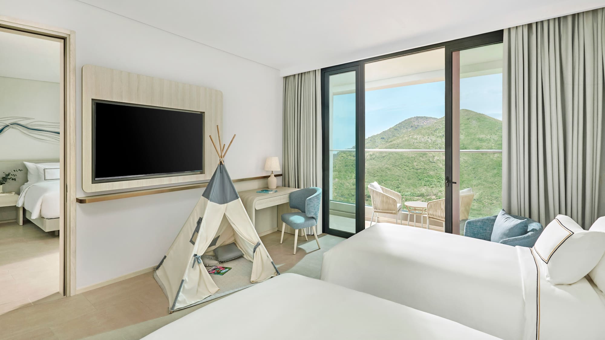 Family room with twin beds, kids' teepee, balcony, and scenic mountain view.