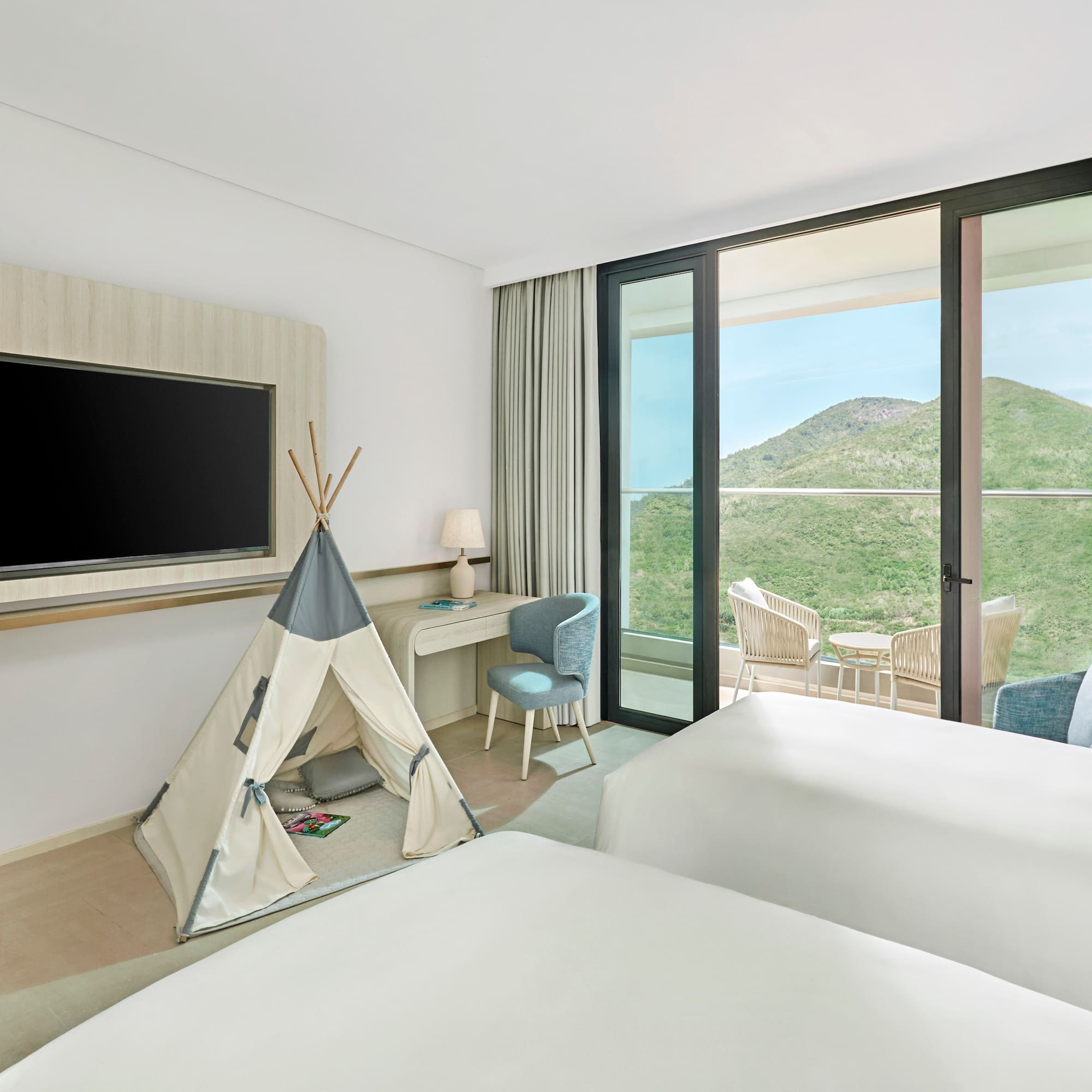 Family room with twin beds, kids' teepee, balcony, and scenic mountain view.