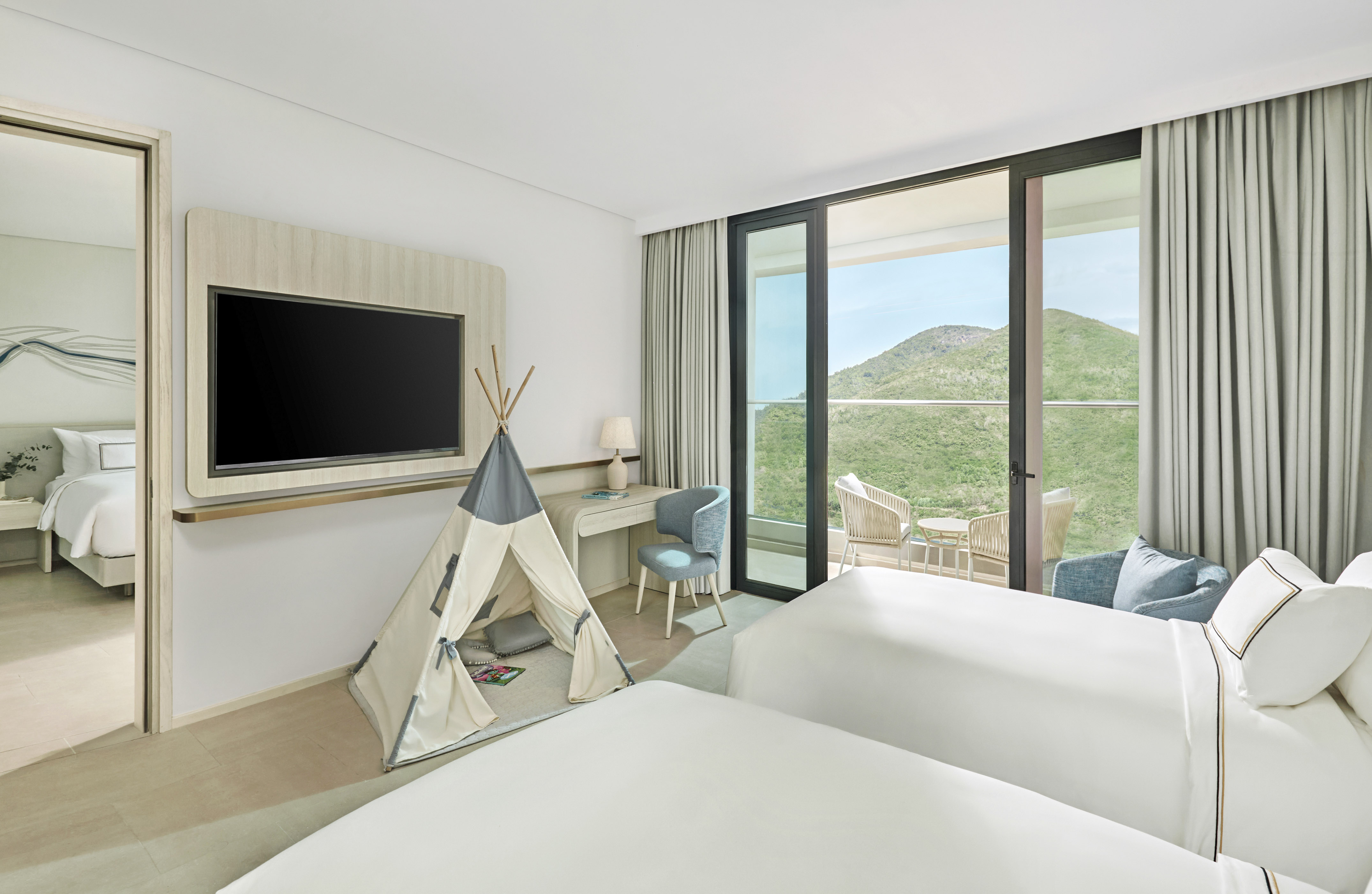 Family room with twin beds, kids' teepee, balcony, and scenic mountain view.