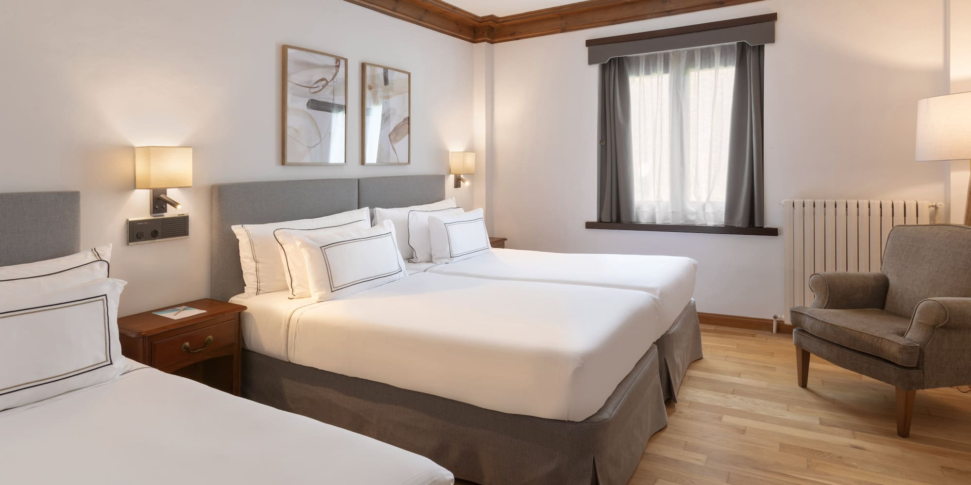 a room with two beds and a wood floor