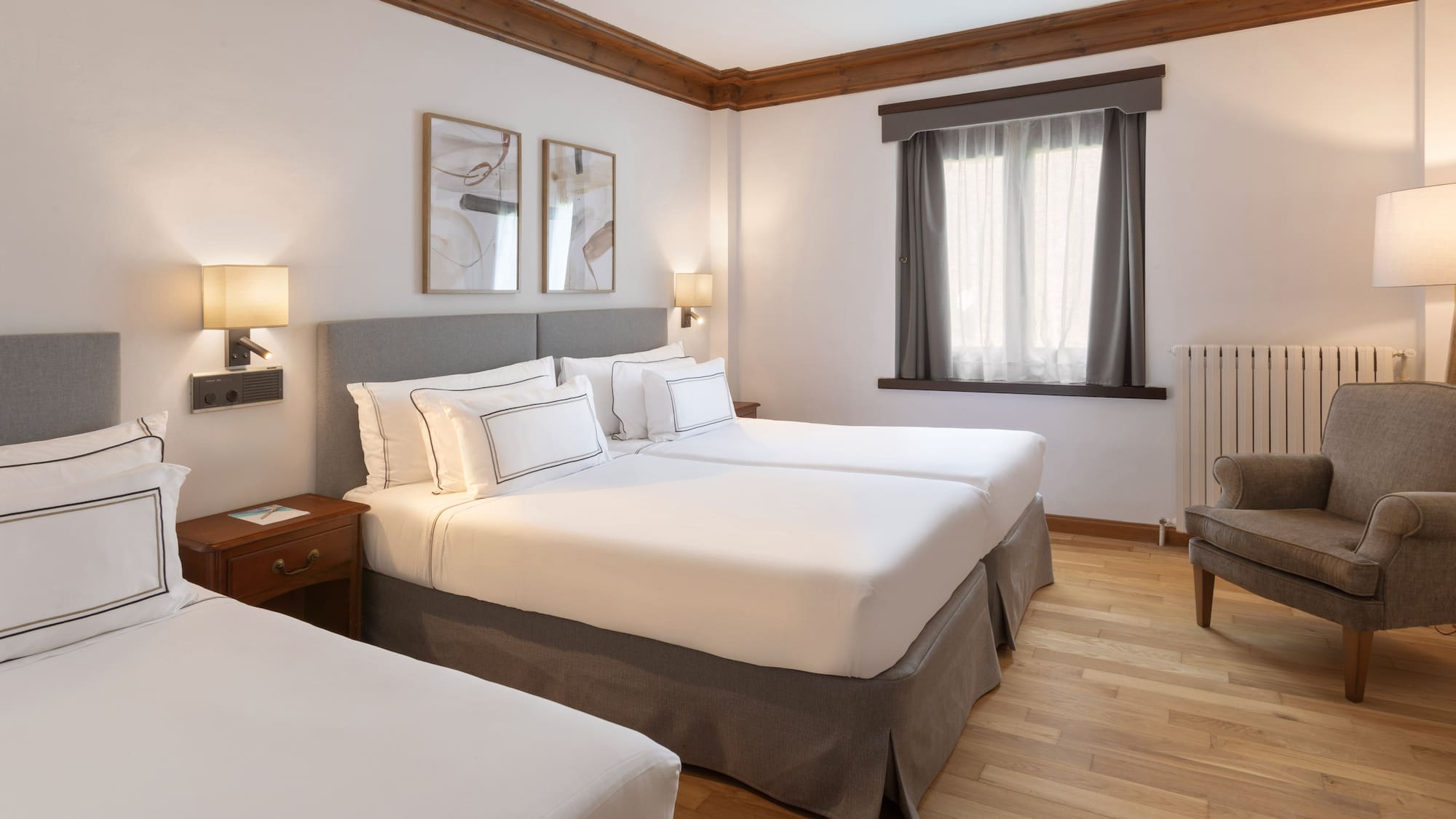 a room with two beds and a wood floor