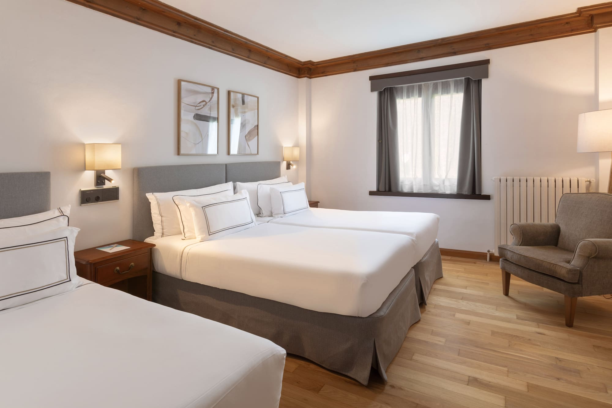 a room with two beds and a wood floor