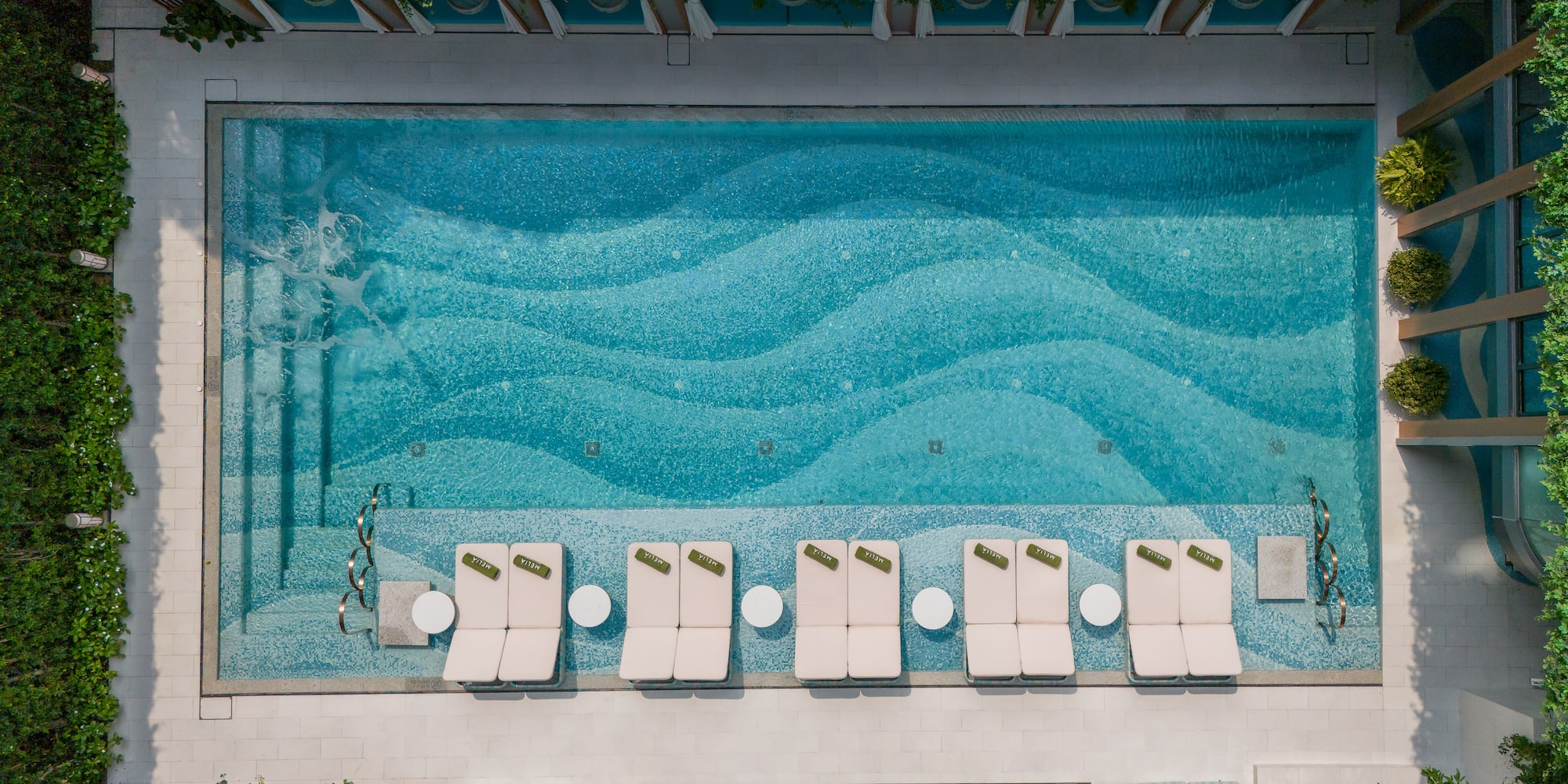 a pool with lounge chairs and a lawn