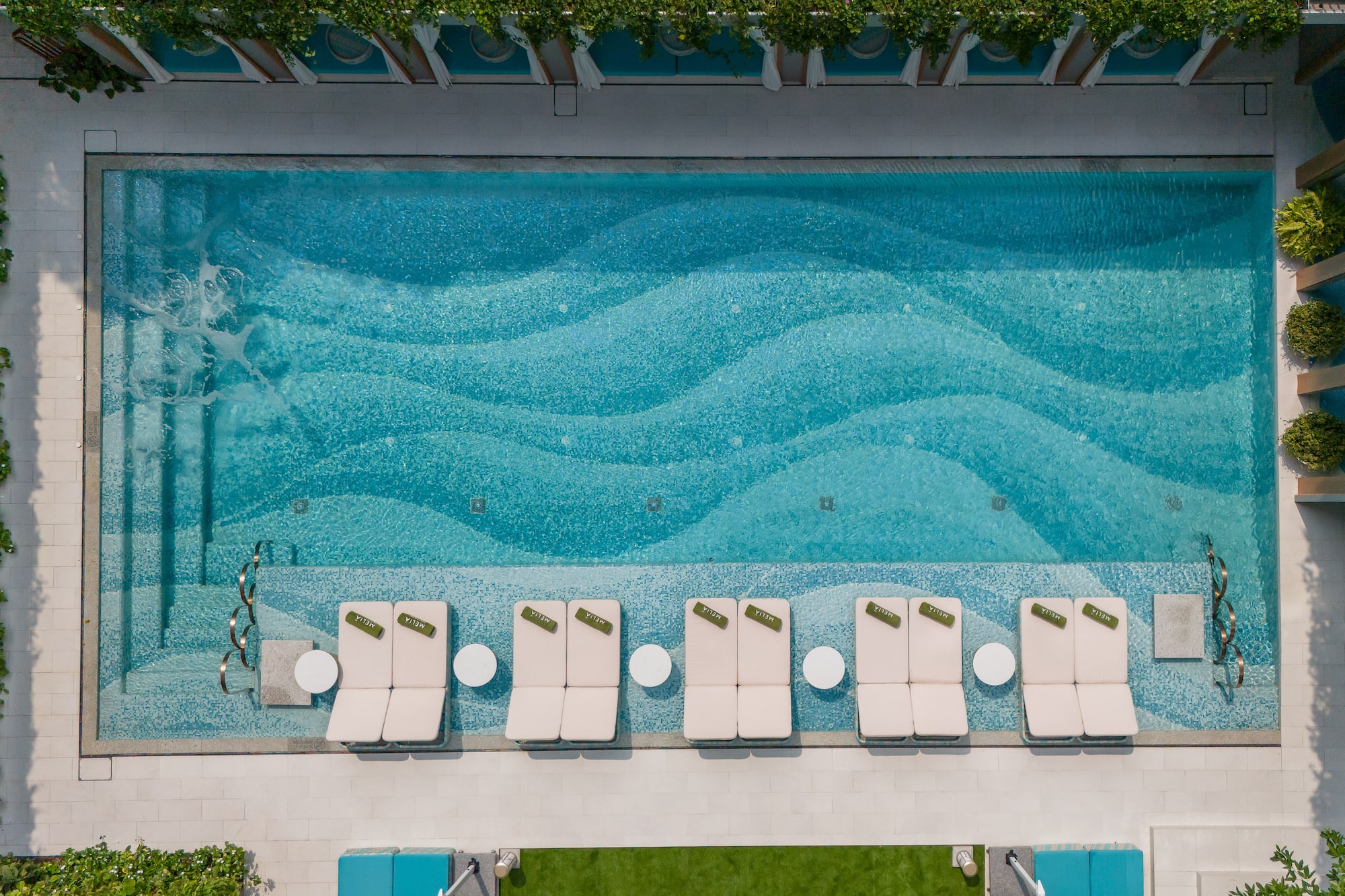 a pool with lounge chairs and a lawn