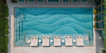 a pool with lounge chairs and a lawn