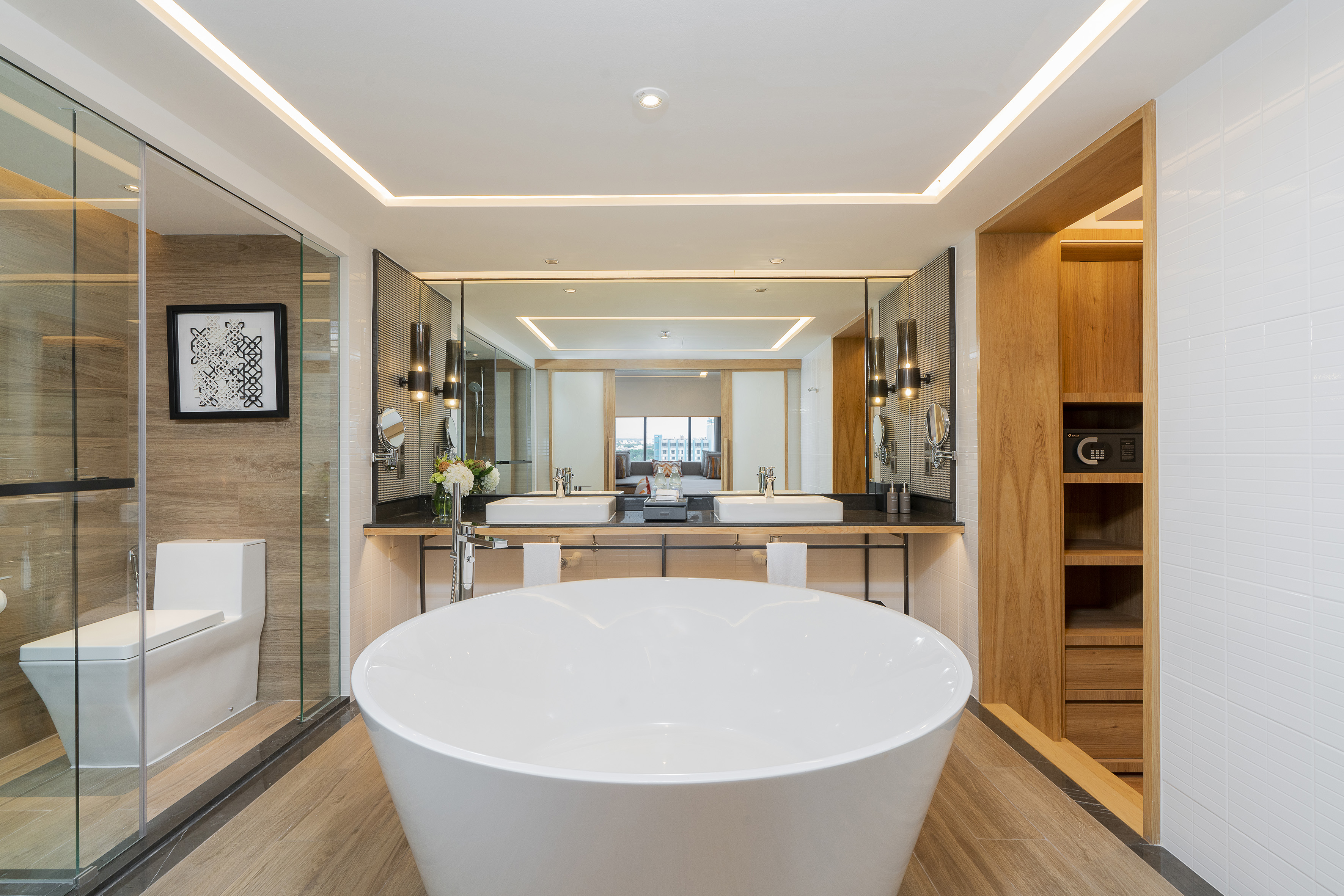 Luxury hotel bathroom with freestanding tub, double vanity, and wood accents.
