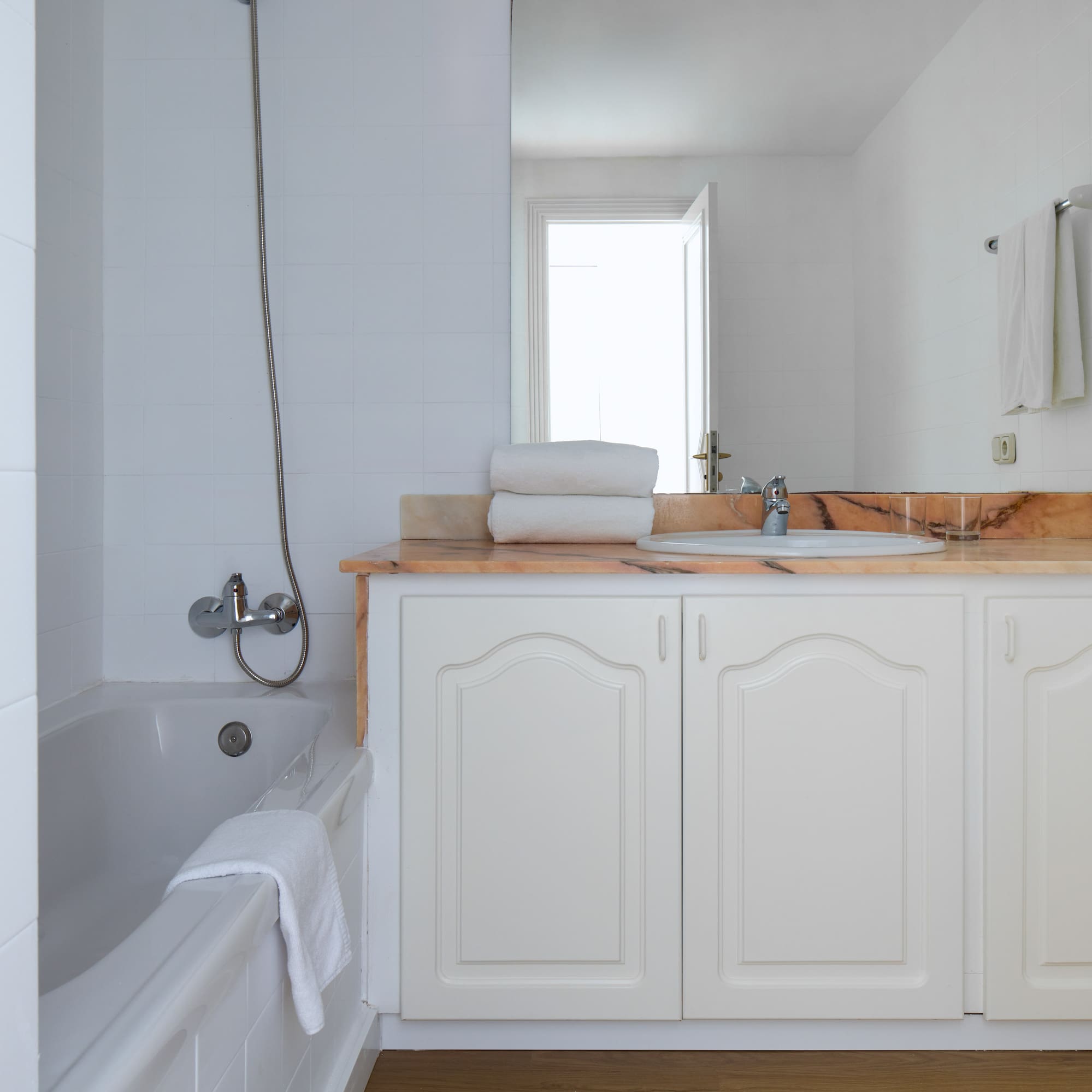 a bathroom with white cabinets and a bathtub