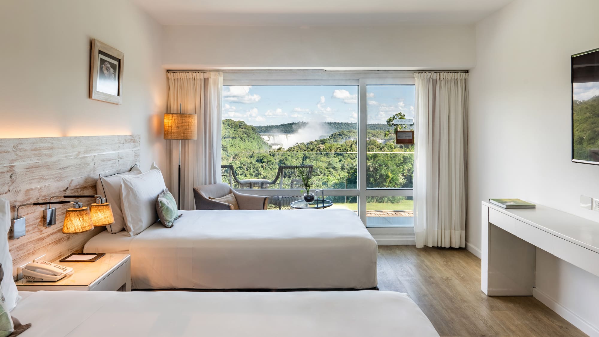 a room with two beds and a large window