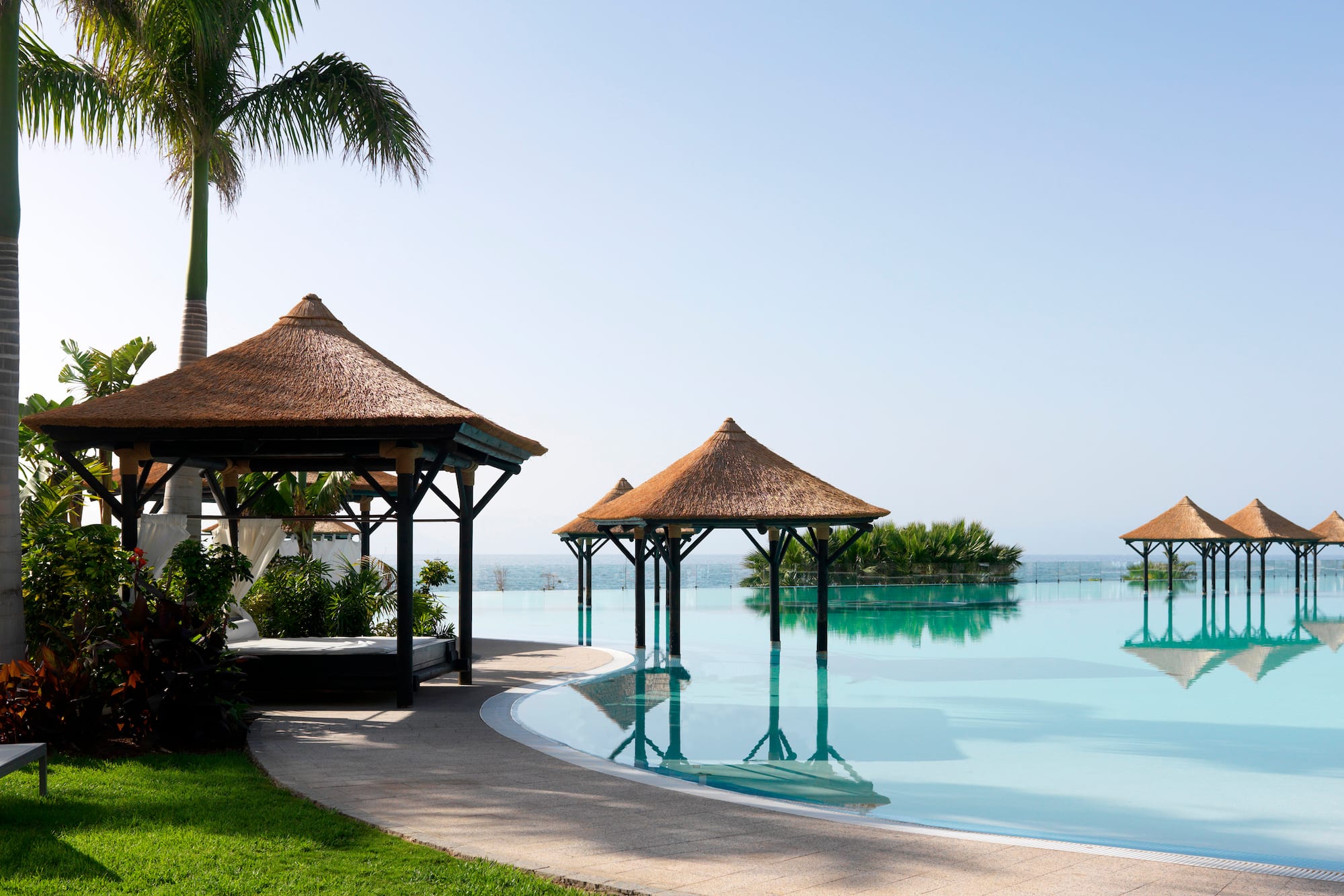 a pool with a gazebo and palm trees