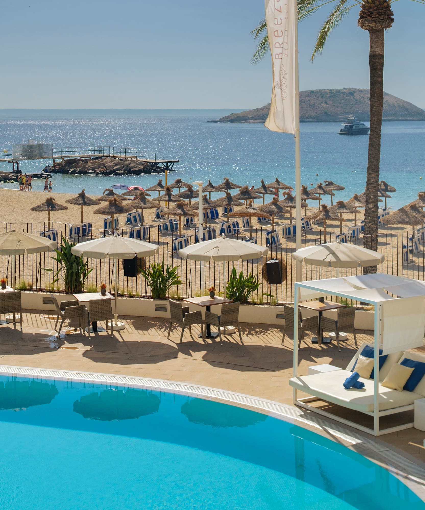 a pool with umbrellas and chairs on a beach