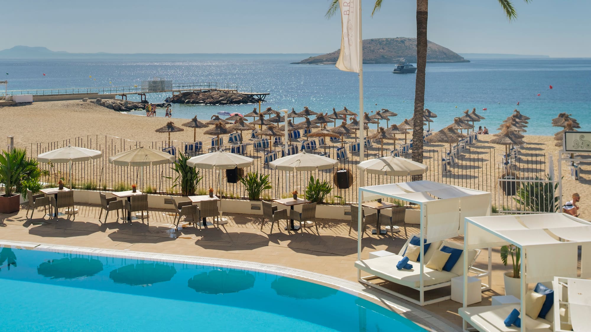 a pool with umbrellas and chairs on a beach