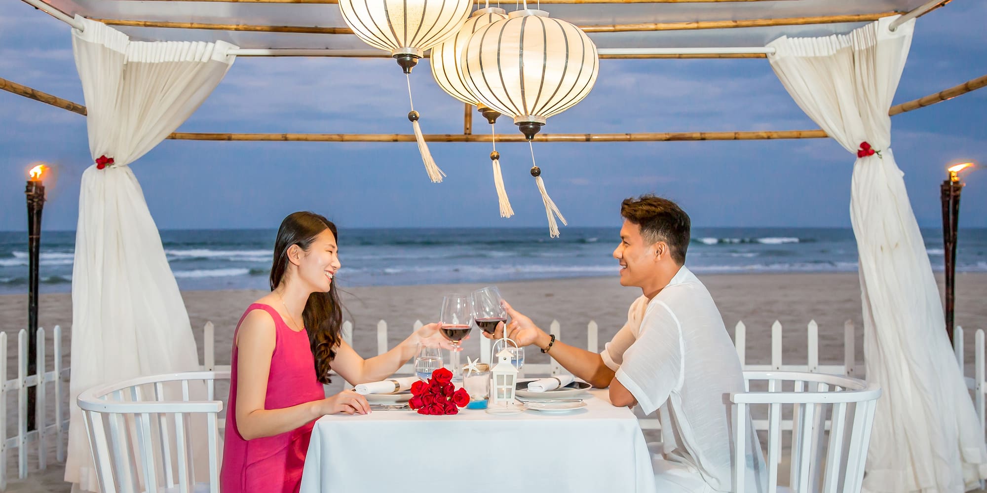 a man and woman sitting at a table with wine glasses
