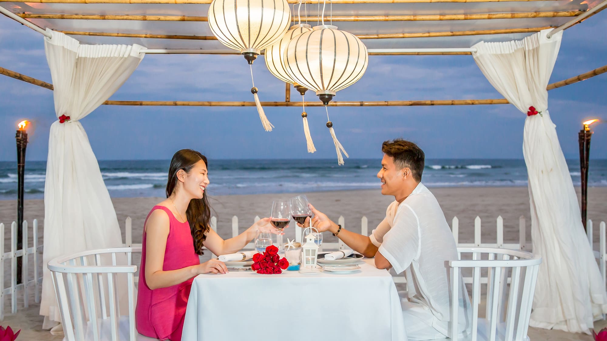 a man and woman sitting at a table with wine glasses