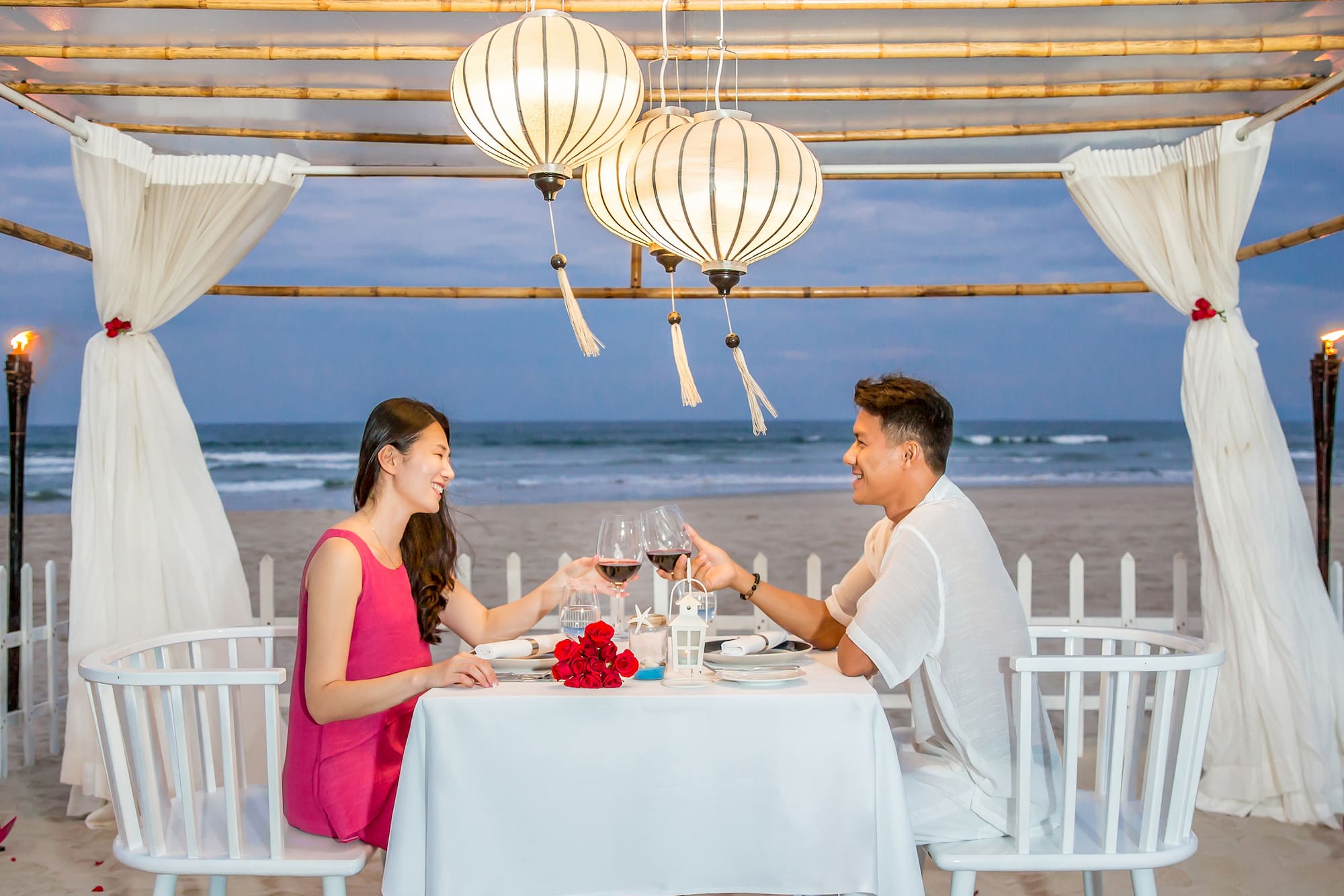 a man and woman sitting at a table with wine glasses