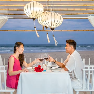 a man and woman sitting at a table with wine glasses