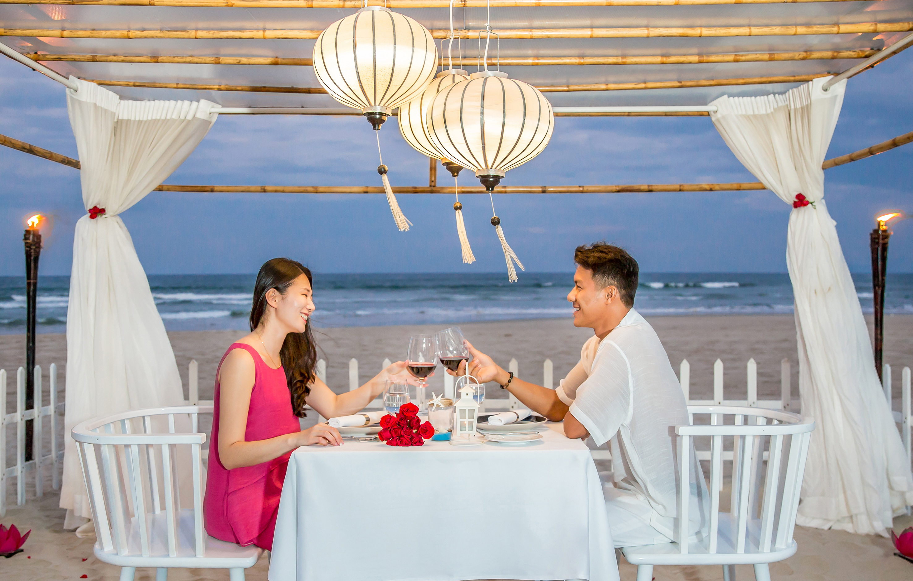 a man and woman sitting at a table with wine glasses