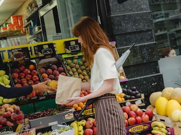 a man and woman walking on a street with shopping bags