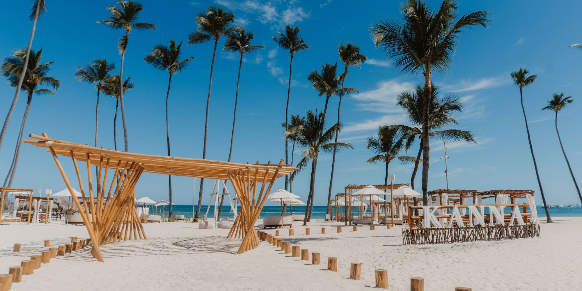 a beach with palm trees and a canopy