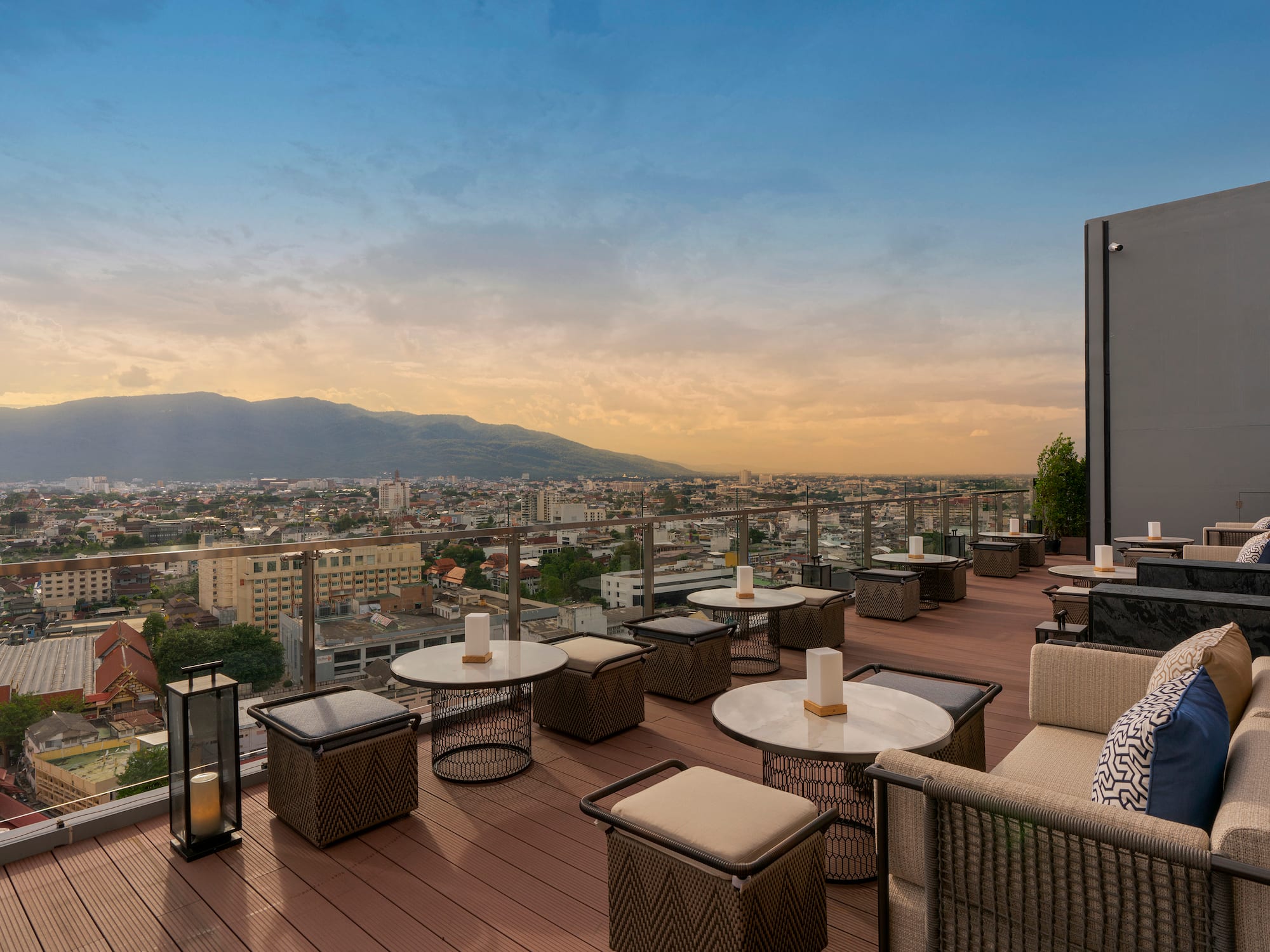 a rooftop patio with tables and chairs and a city view