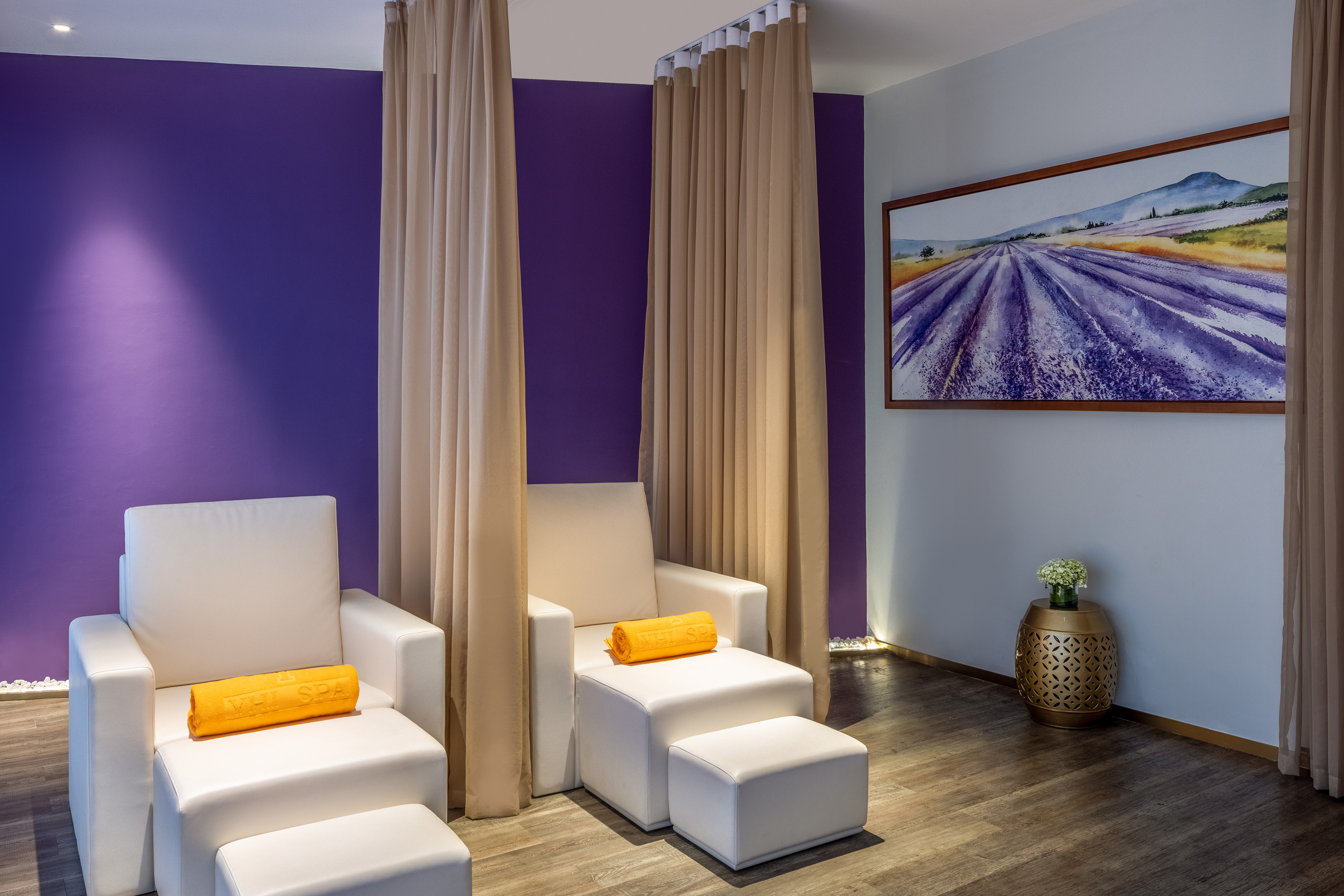 VHL SPA: white spa chairs with footrests, purple wall, lavender field painting.