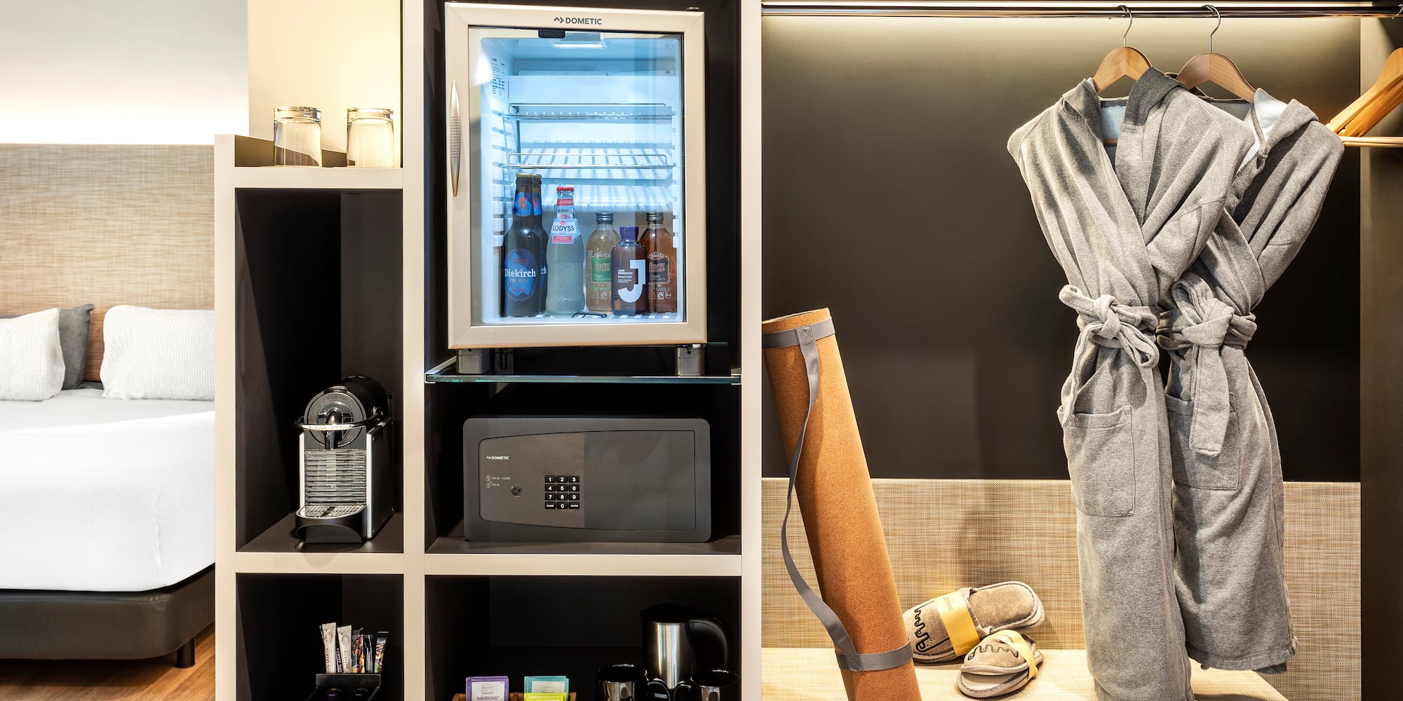 a room with a small refrigerator and a robe