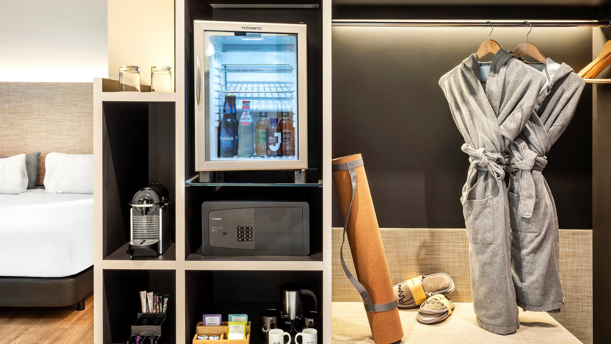 a room with a small refrigerator and a robe